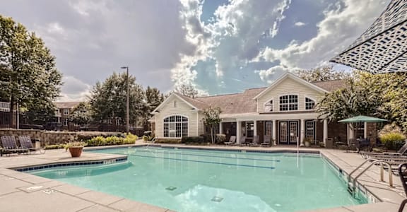 A large swimming pool in front of a house.