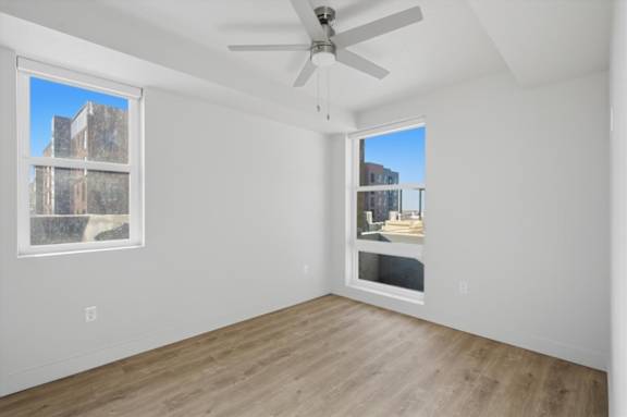 A room with a ceiling fan and two windows at Brickside Heights, Millcreek, Utah
