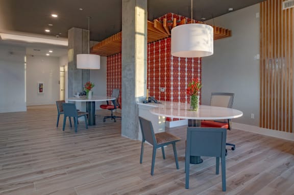 a dining area with a round table and chairs and a large pillar with a wall