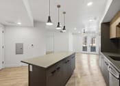 Thumbnail 12 of 51 - A kitchen with a large island and pendant lights at Brickside Heights, Millcreek, Utah
