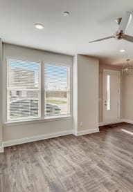 an empty living room with a ceiling fan