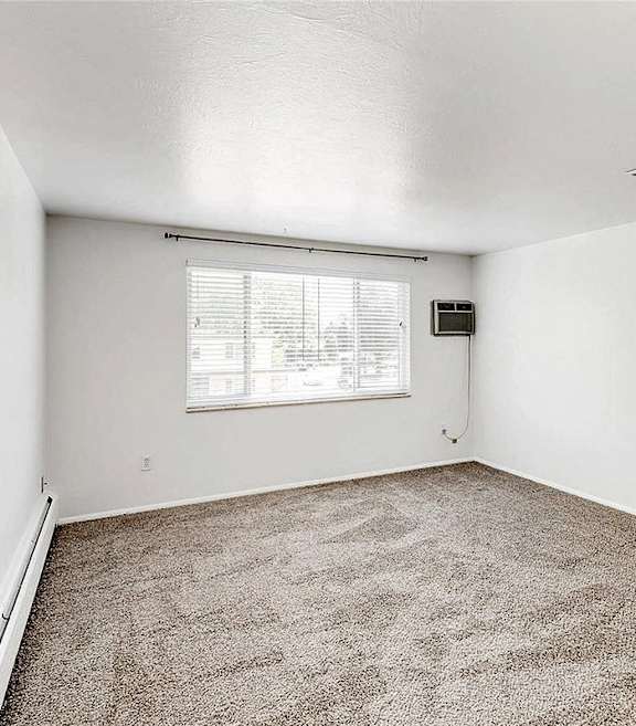 A room with a window and carpeted floor.