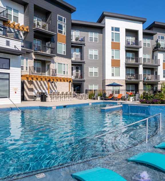 A swimming pool in front of apartment buildings.