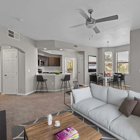 A living room with a white couch and a ceiling fan.