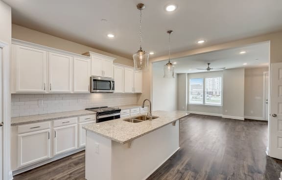 a kitchen with white cabinets and a white island with a sink
