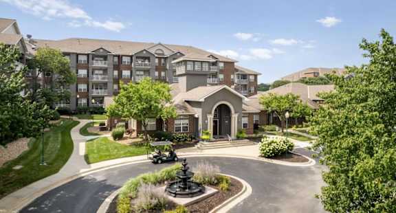 a living room with a kitchen in the background at The Claremont Apartment Homes, Overland Park Kansas
