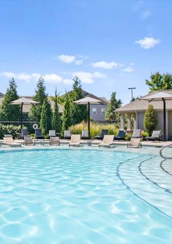 The beautiful outdoor pool with lounge seating at Stonepost Crossing in Overland Park.