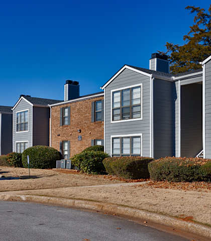 A row of houses with a car parked in front of them.