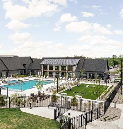 an aerial view of a pool with a building in the background  at Slate at Fishers District, Fishers, IN