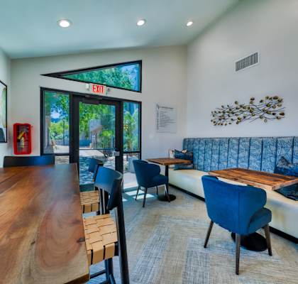 A living room with a couch, chairs, and a wooden table.