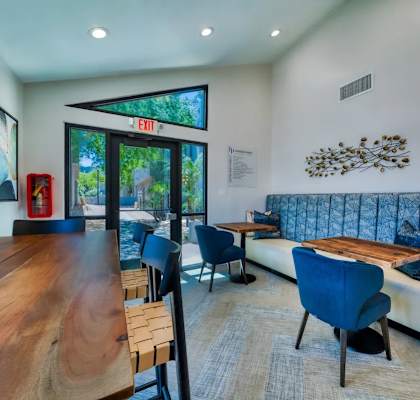 A modern living room with a wooden table and blue chairs.