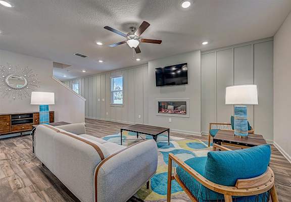 a living room with a fireplace and a ceiling fan