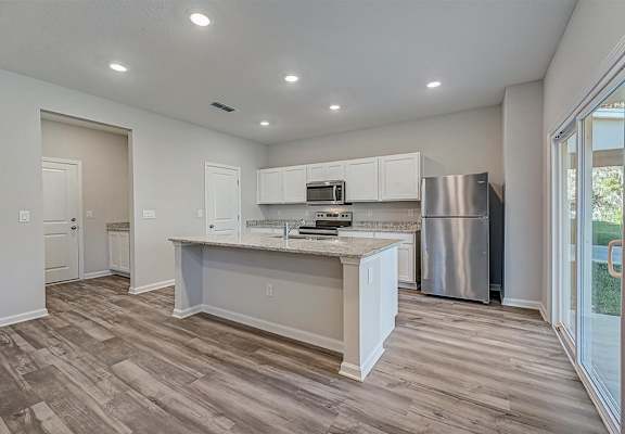a kitchen with a large island and stainless steel appliances