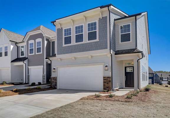 a house with a gray siding and a white garage door