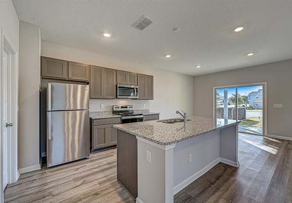 a kitchen with a large island and stainless steel appliances