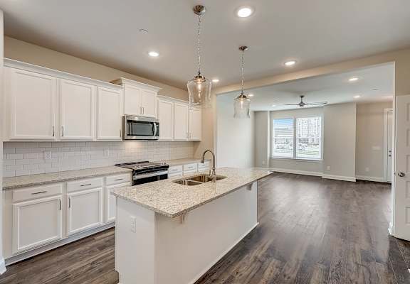 a kitchen with white cabinets and a white island with a sink