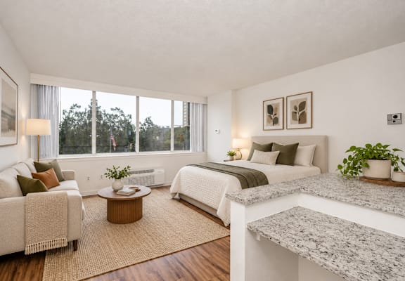 A well-lit bedroom with a large bed, a couch, and a coffee table.