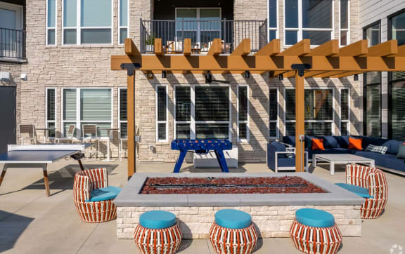an outdoor patio with a fire pit and tables
