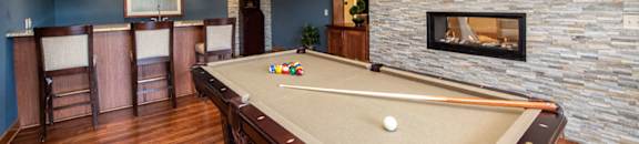 a game room with a pool table and a fireplace