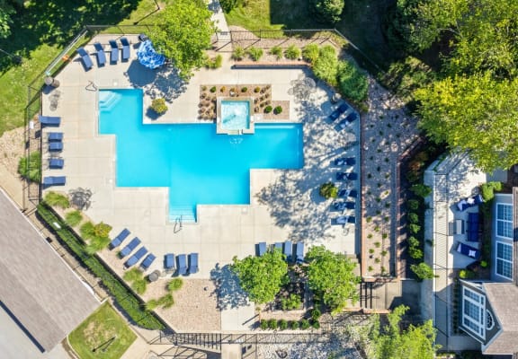 arial view of a swimming pool in a backyard with lounge chairs and treesat Stonebriar Apartments, Overland Park, 66213