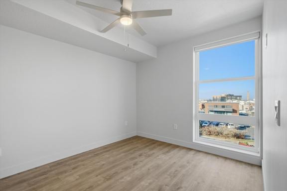Empty room with a window overlooking a parking lot at Brickside Heights, Millcreek, Utah