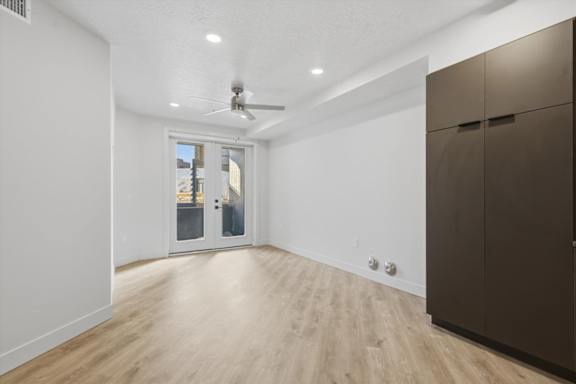 A room with a ceiling fan and wooden flooring at Brickside Heights, Millcreek, UT