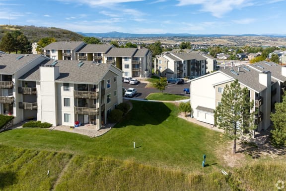 an aerial view of a group of apartment buildings with grass and trees