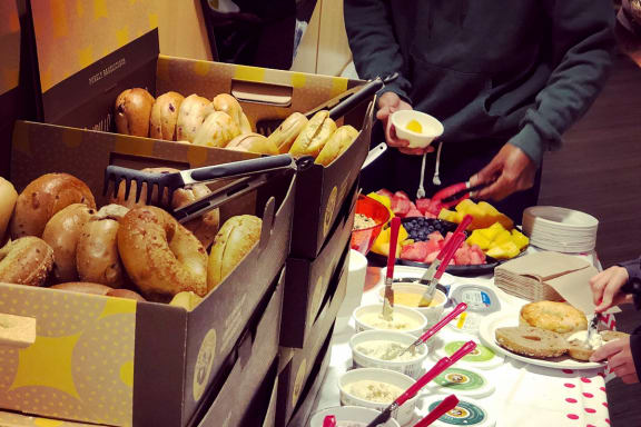a table full of bagels and other food