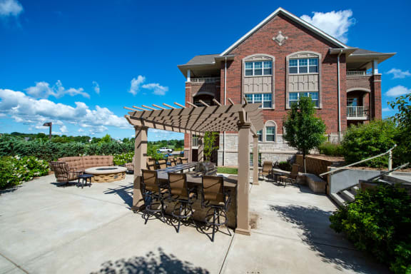 a patio with a table and chairs in front of a building