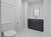 Thumbnail 3 of 4 - A white toilet is in a bathroom with a black cabinet at Hampton Plaza Apartments, Towson, MD, 21286