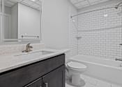 Thumbnail 4 of 4 - A white bathroom with a toilet, sink, and bathtub at Hampton Plaza Apartments, Towson, MD, 21286