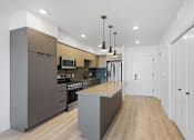 Thumbnail 22 of 51 - A modern kitchen with a large island in the middle at Brickside Heights, Millcreek