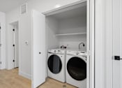 Thumbnail 19 of 51 - A white laundry room with two open washing machines at Brickside Heights, Utah, 84106