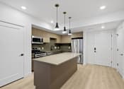 Thumbnail 16 of 51 - A modern kitchen with a large island and pendant lights at Brickside Heights, Millcreek