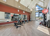 Thumbnail 21 of 52 - A gym with a variety of equipment including treadmills, weights, and exercise machines at Solhavn Apartments, American Fork, UT, 84003