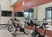 Thumbnail 22 of 52 - A gym with stationary bikes and a flat screen TV at Solhavn Apartments, American Fork