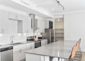 Thumbnail 21 of 25 - A modern kitchen with white cabinets and appliances.