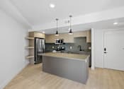 Thumbnail 45 of 51 - A modern kitchen with a large island and stainless steel appliances at Brickside Heights, Millcreek, UT