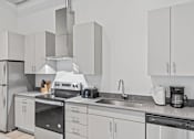 Thumbnail 22 of 25 - A modern kitchen with white cabinets and stainless steel appliances.
