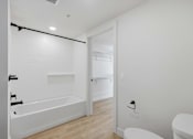 Thumbnail 24 of 51 - A white bathroom with a toilet, sink, and bathtub at Brickside Heights, Millcreek, Utah