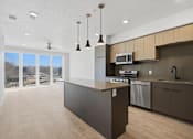 Thumbnail 35 of 51 - A kitchen with a large island and a microwave above it at Brickside Heights, Millcreek, 84106