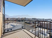 Thumbnail 34 of 51 - A balcony with a view of a parking lot and mountains at Brickside Heights, Millcreek