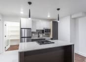 Thumbnail 2 of 4 - a kitchen with an island and a refrigerator and a sink