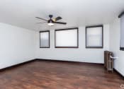 Thumbnail 3 of 4 - an empty living room with a ceiling fan and three windows