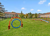 Thumbnail 4 of 5 - A playground with a blue and orange ring structure and a blue and orange slide.
