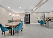 Thumbnail 4 of 5 - A modern dining room with a round table and blue chairs.