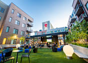Thumbnail 3 of 8 - an outdoor area with tables and chairs and a building in the background at CityWay Apartments, Indianapolis, IN, 46204