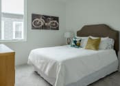 Thumbnail 6 of 8 - a bedroom with a bed and a painting of a bike on the wall