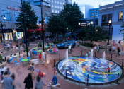 Thumbnail 9 of 9 - a city square with a fountain in the middle and people walking around it