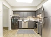 Thumbnail 4 of 13 - a kitchen with gray cabinets and stainless steel appliances at Copper and Quarry Village, Pikesville, MD, 21209